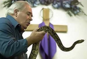 Man holding snake cross background